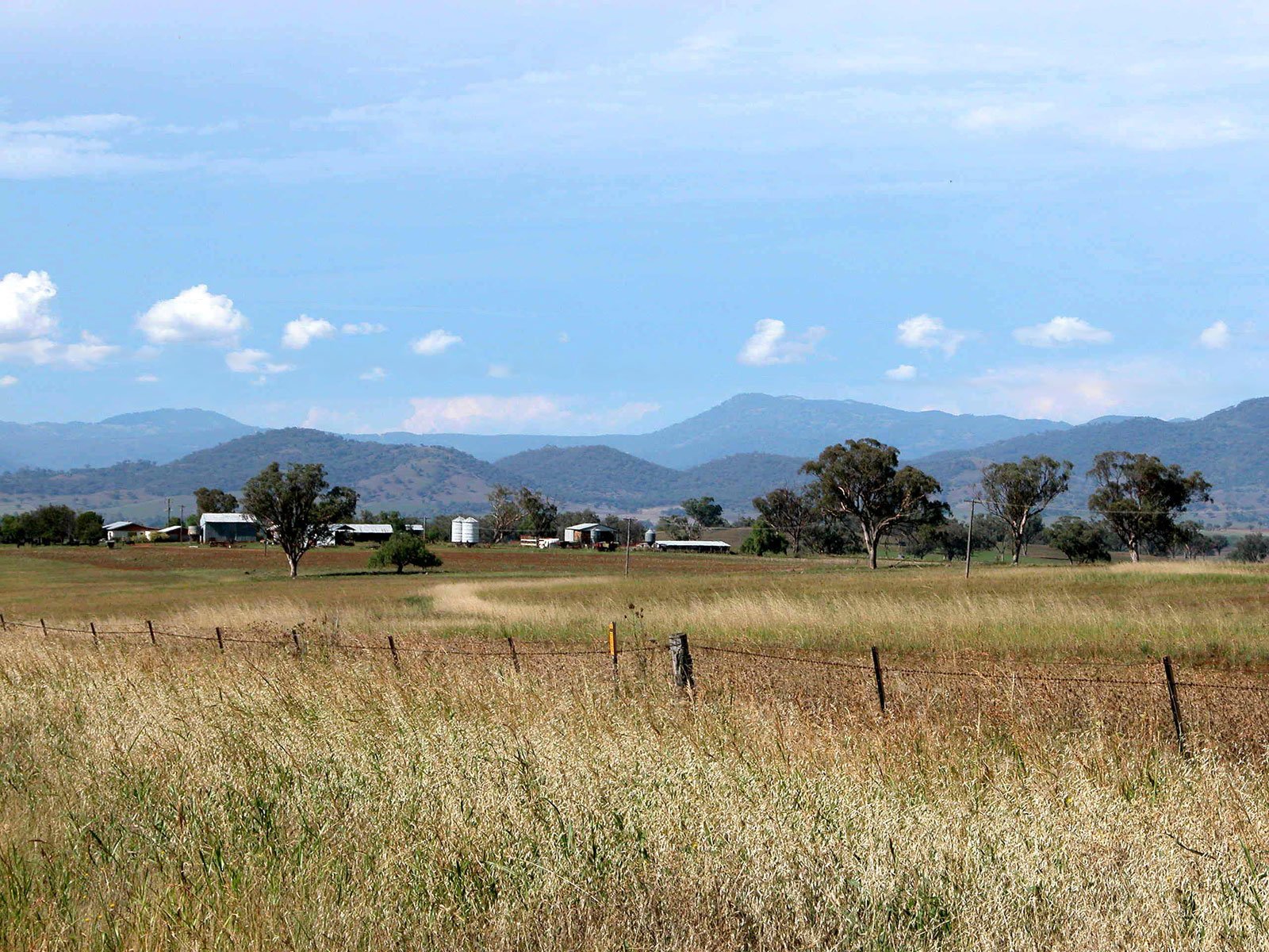 an empty field with a few distant mountains in the distance