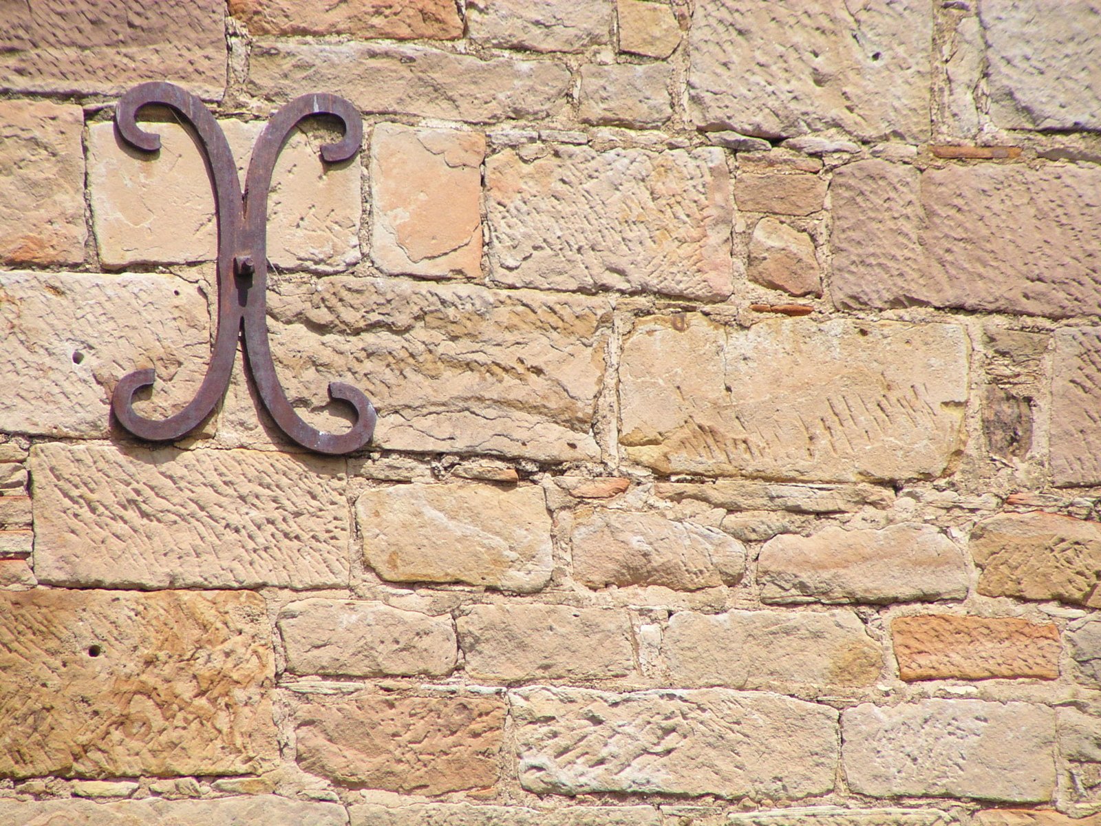 a metal letter is mounted to a brick wall