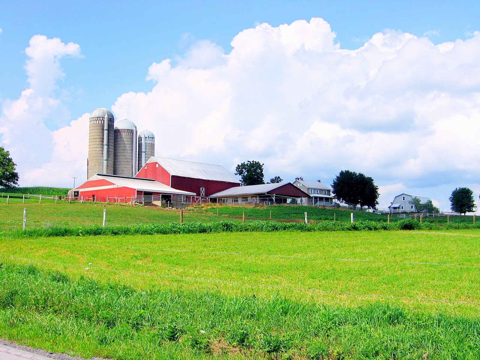 a farm with many different buildings near grass