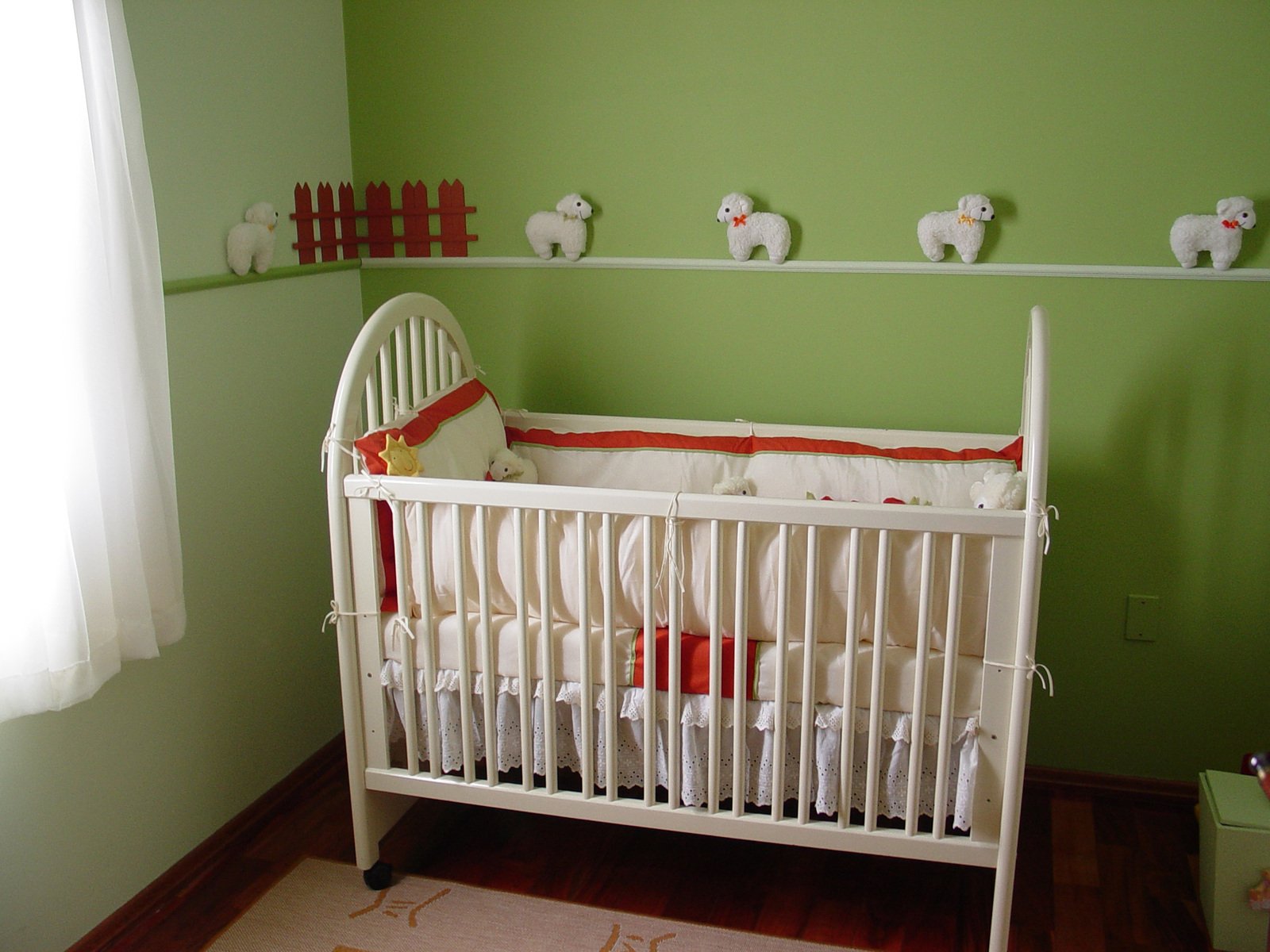 a white baby crib in a room painted green