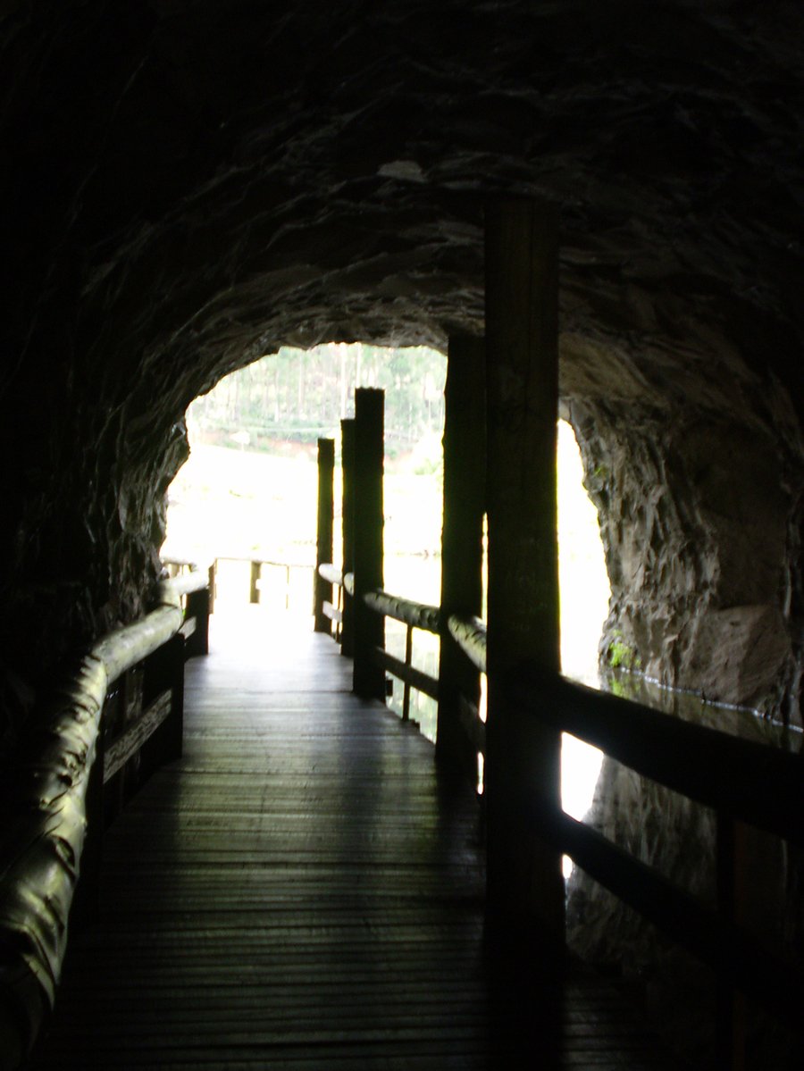 the dark tunnel is dimly lit by a bridge