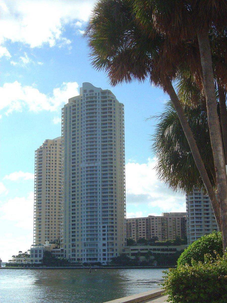 a high rise building sitting on the edge of a body of water