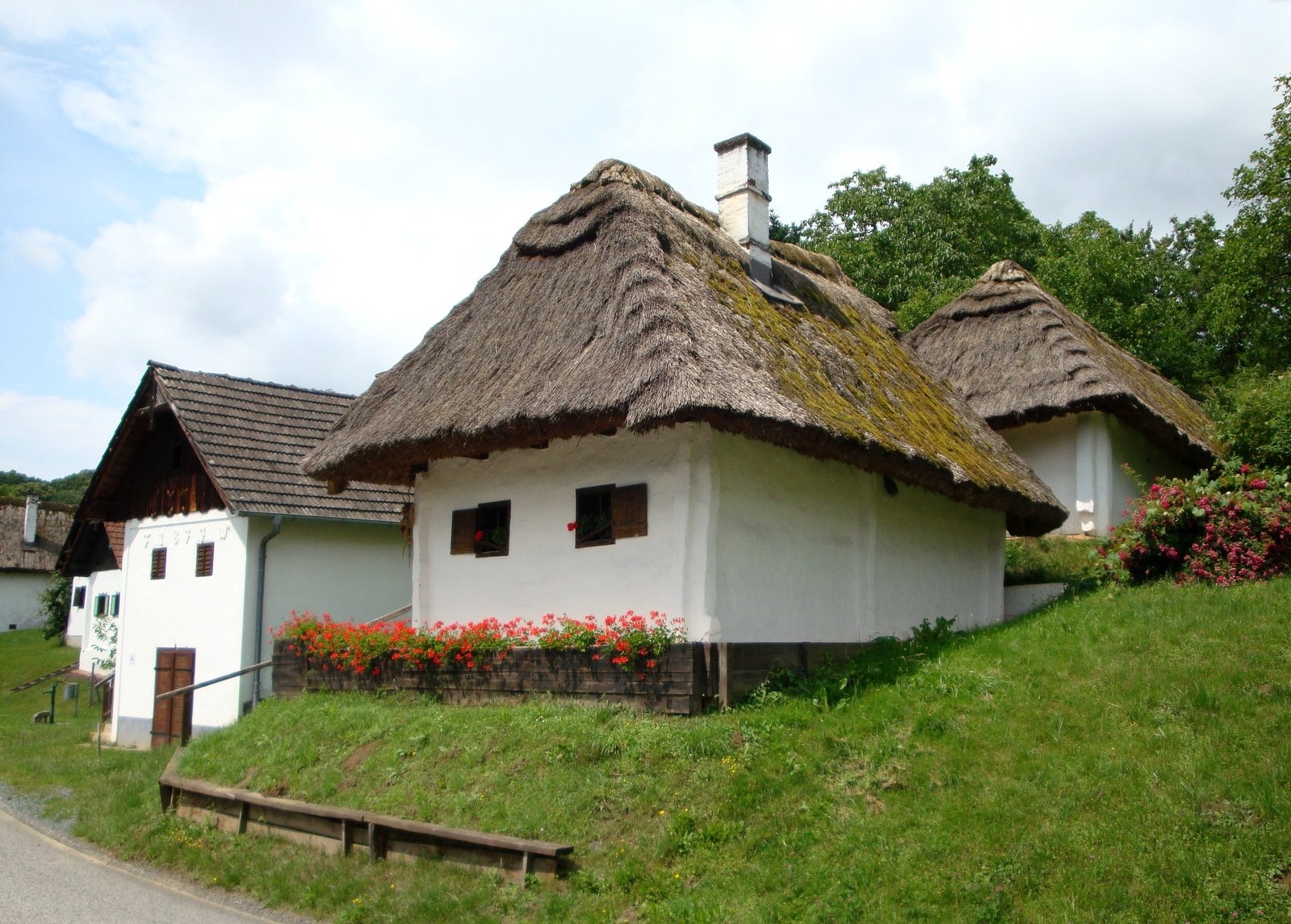 small white building with green grass on top of it