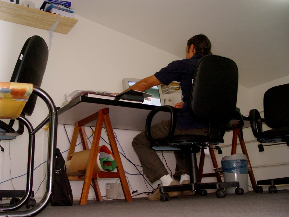 a man at a desk working on a computer in an attic office