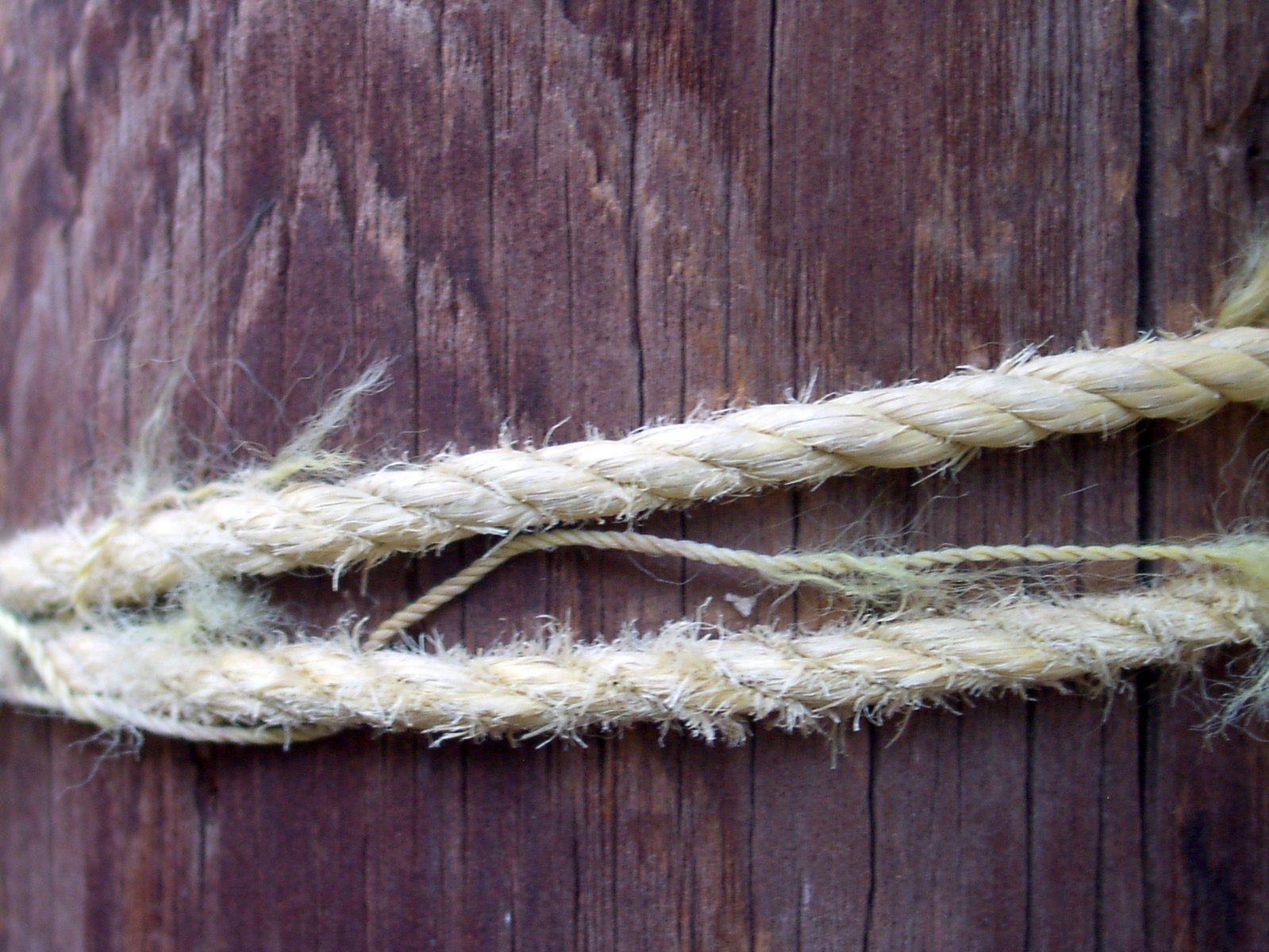 closeup of rope wrapped in thick cord on the wooden post