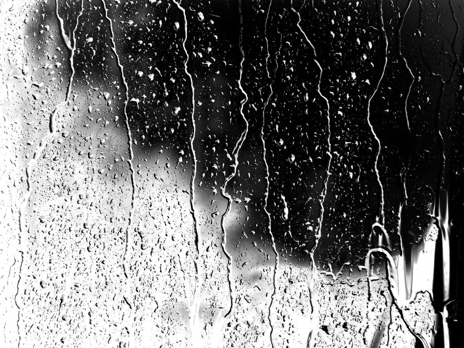 a window that has rain on it in the dark