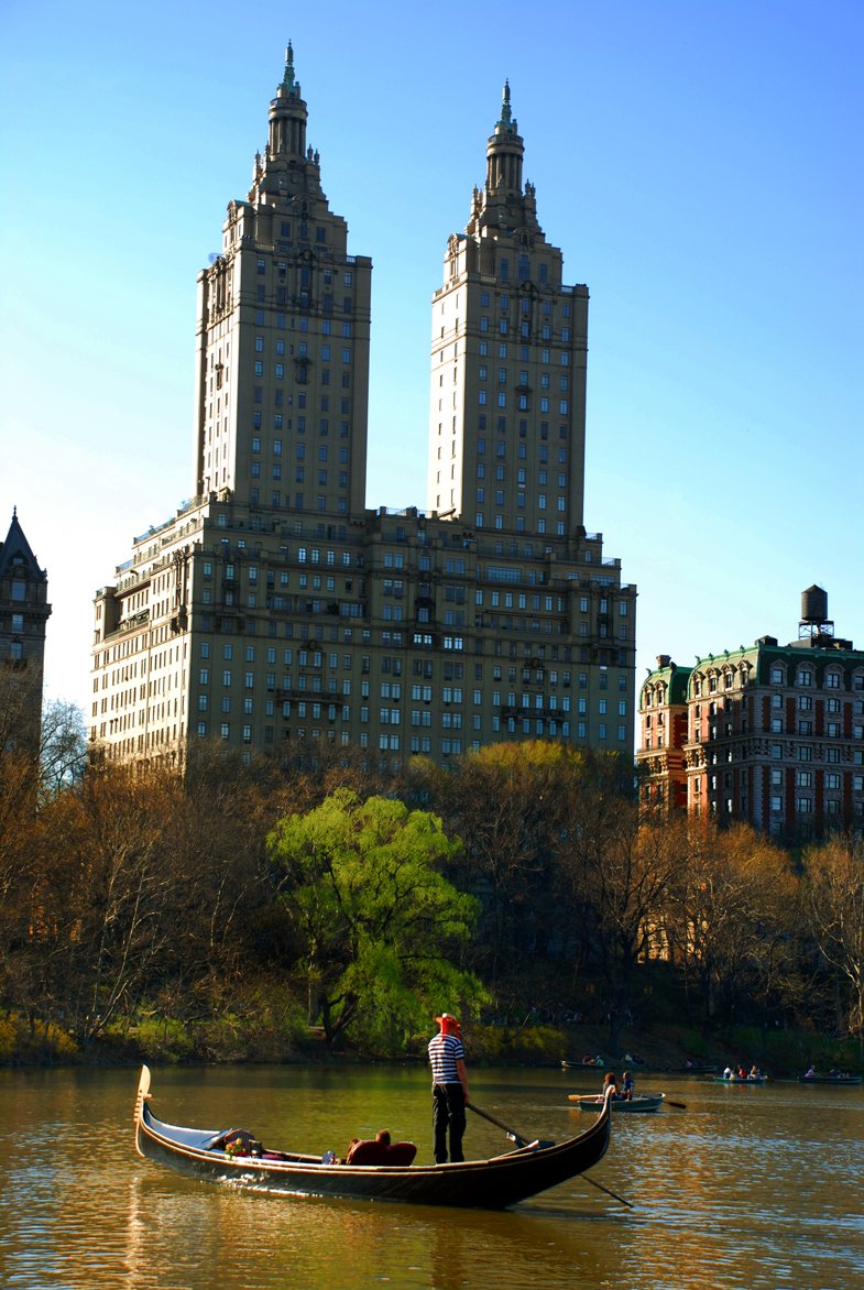 a man is floating in a boat next to buildings