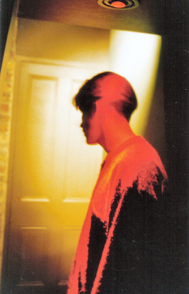 the silhouette of a young man is seen in front of a doorway