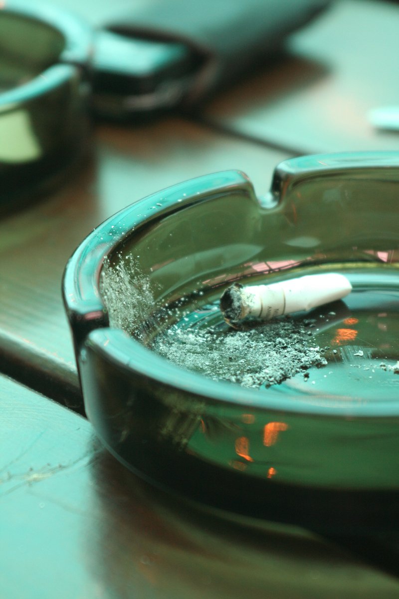 the ashtray is in the water with some cigarettes