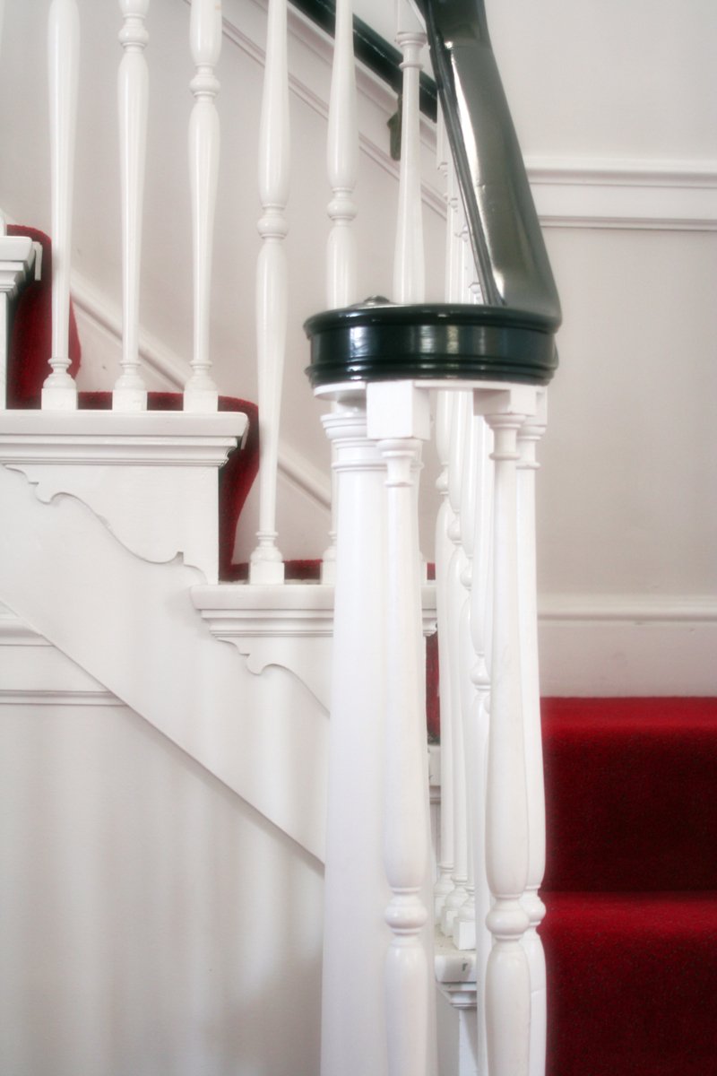 some white hand rails are by the red stairs