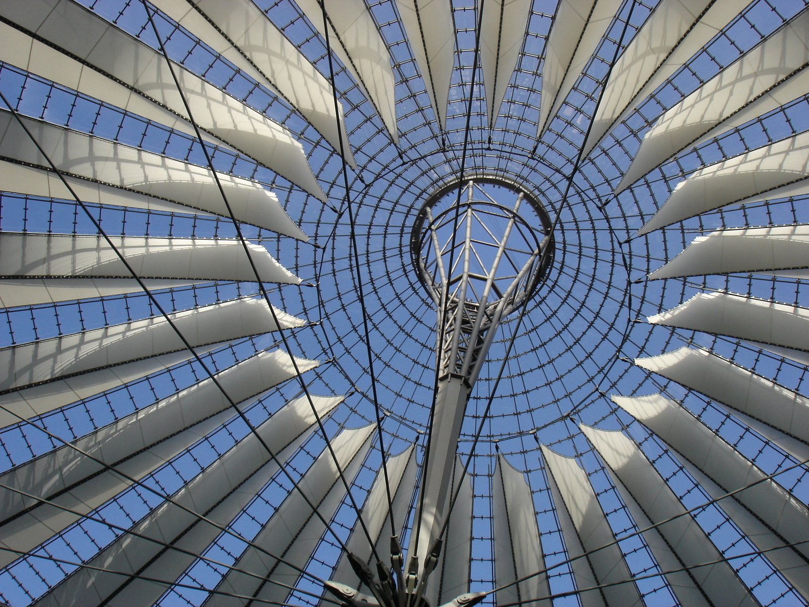 looking up at the roof of a circular building with large glass panels