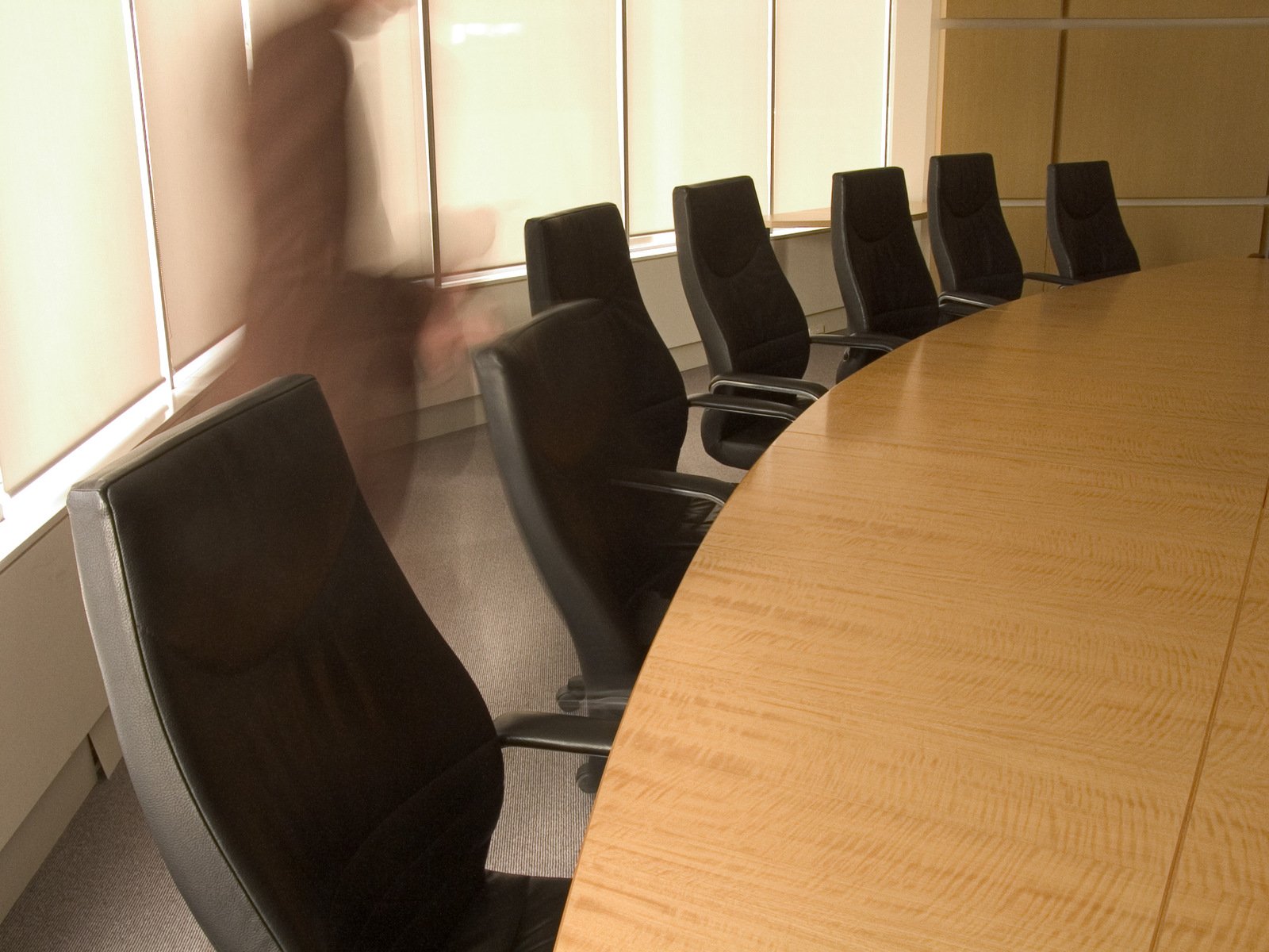 a large wooden table sits in a meeting room