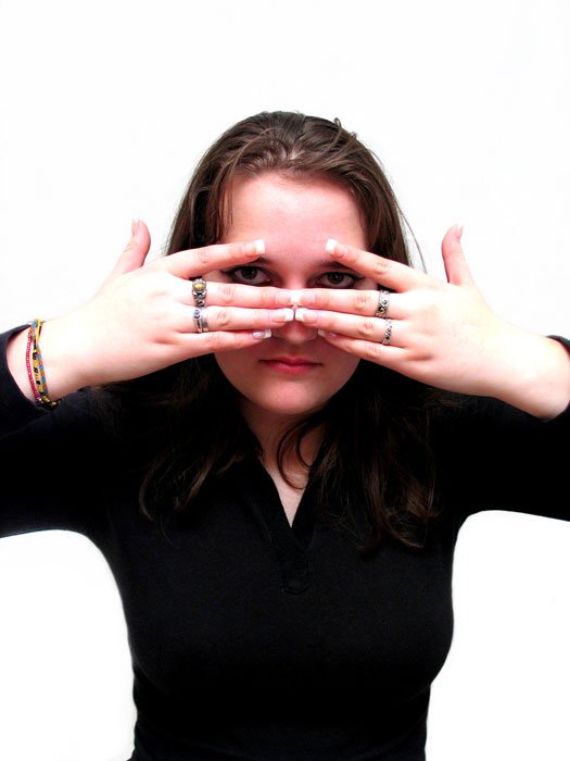 a woman with her fingers pressed up over the top of her eyes