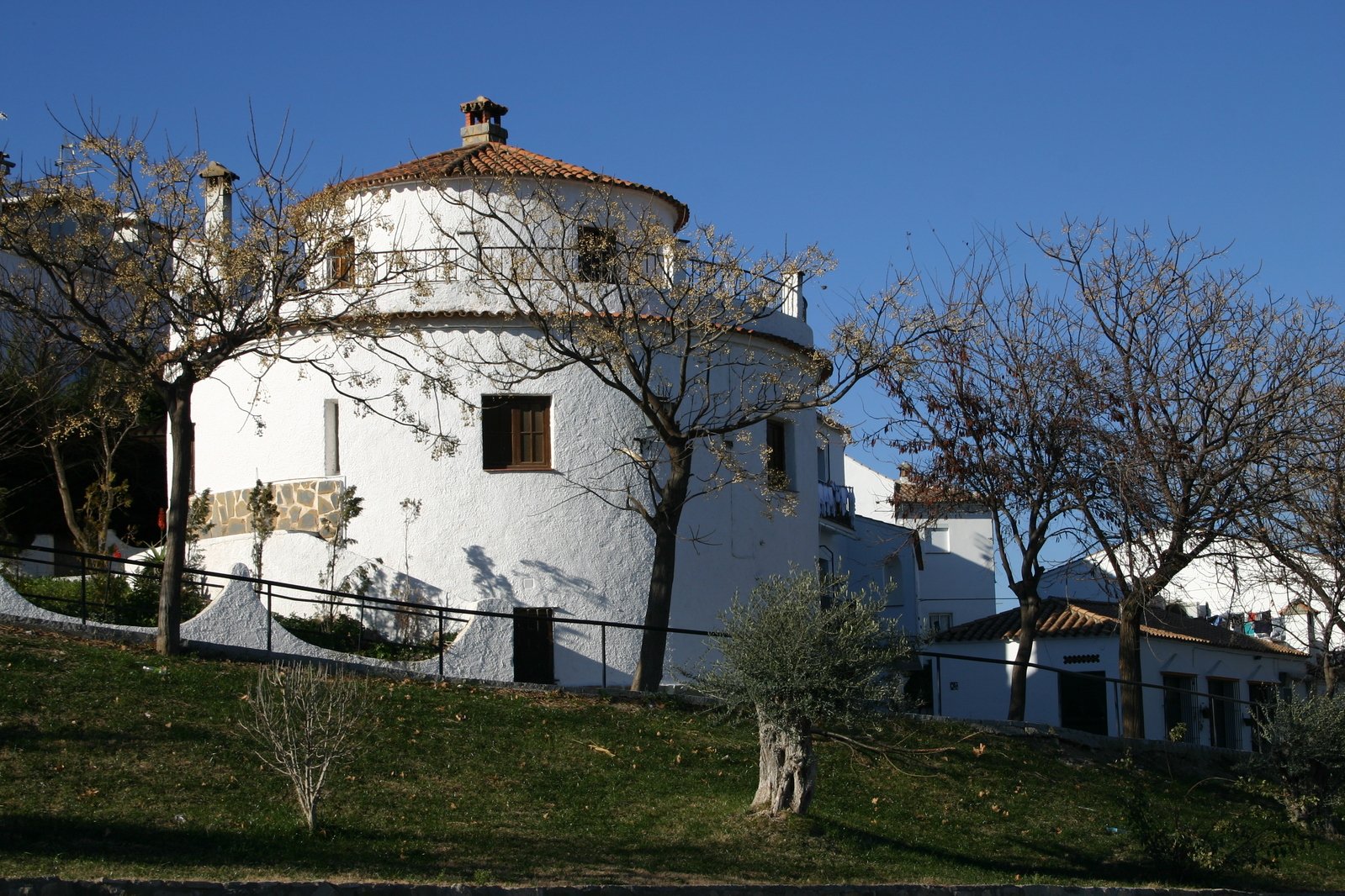 a tall white building with a brown roof