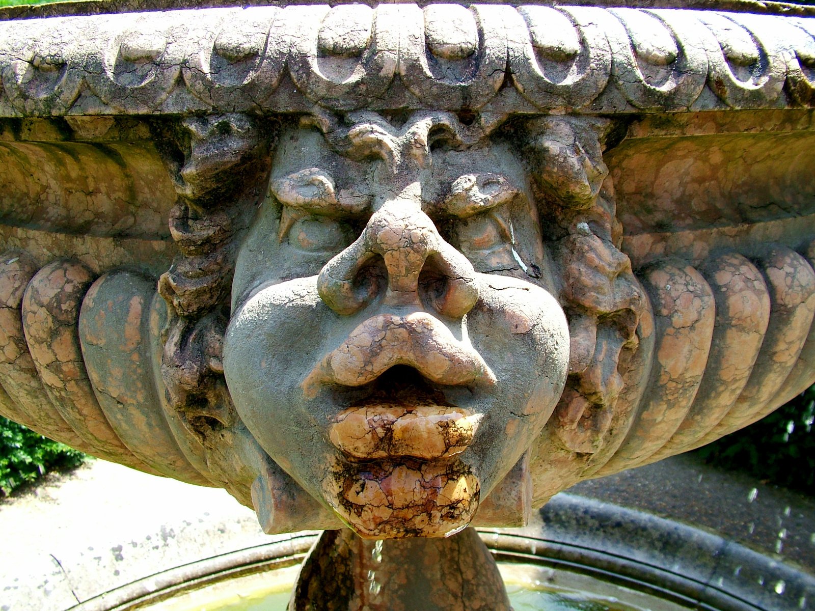 a stone urn with a weird face at its center