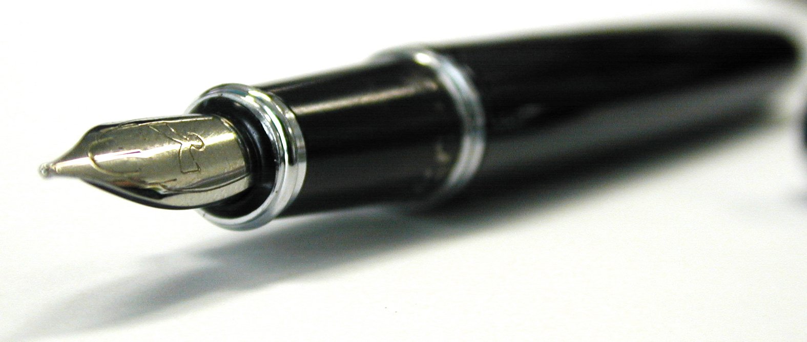 an aluminum pen on white background next to a metal object