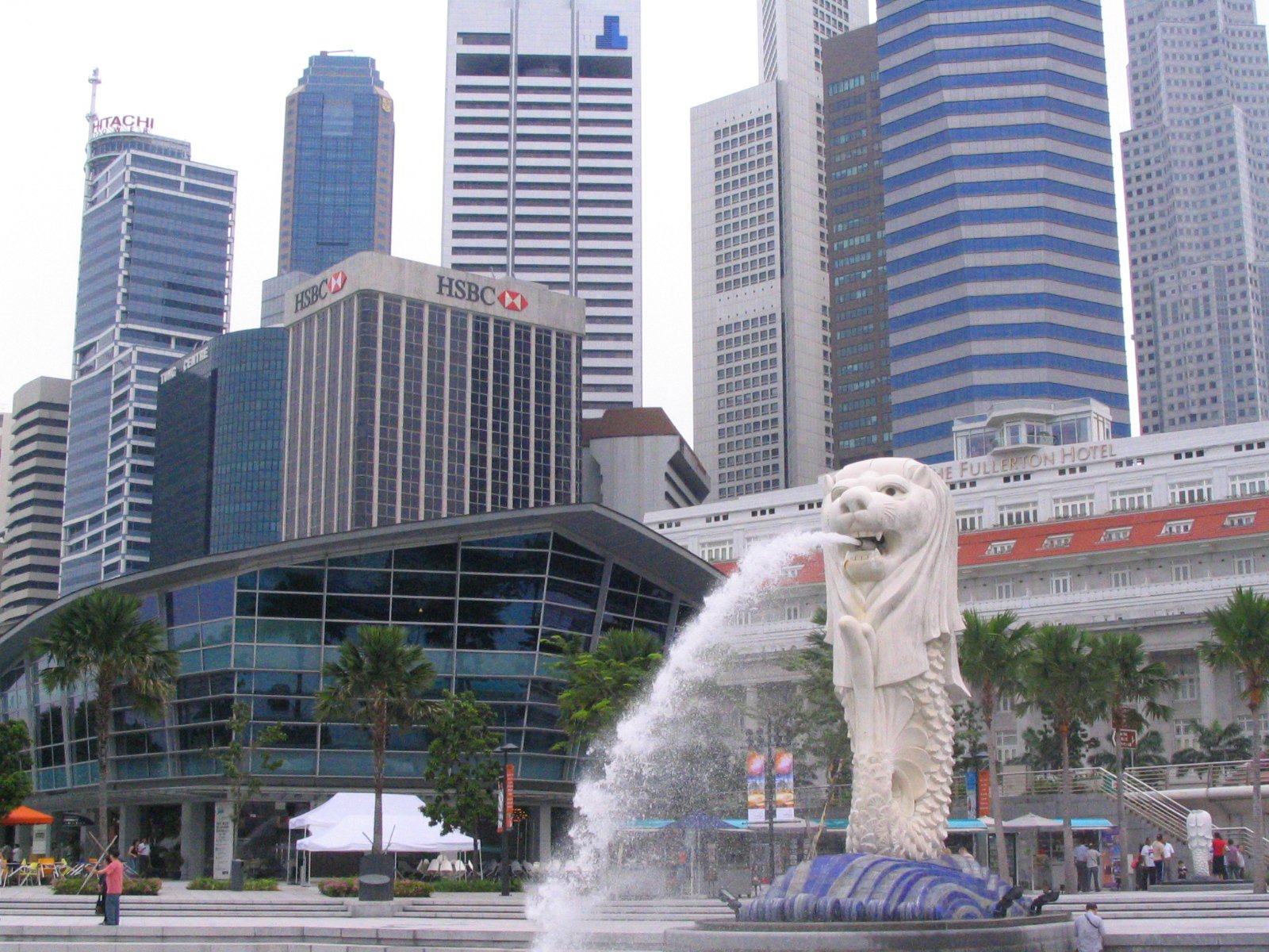 a white polar bear standing in front of a fountain