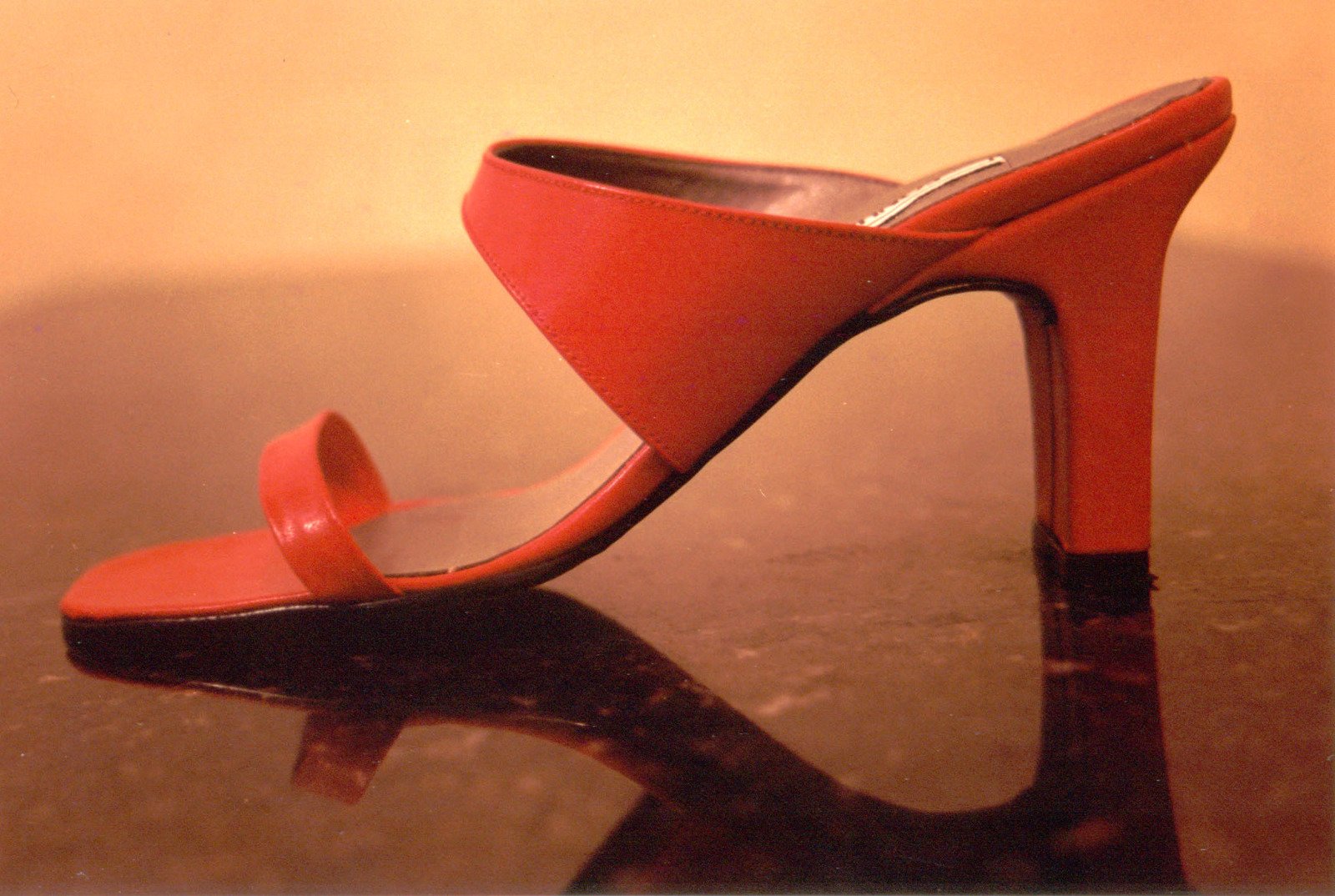 red shoes sitting on top of a table near a glass