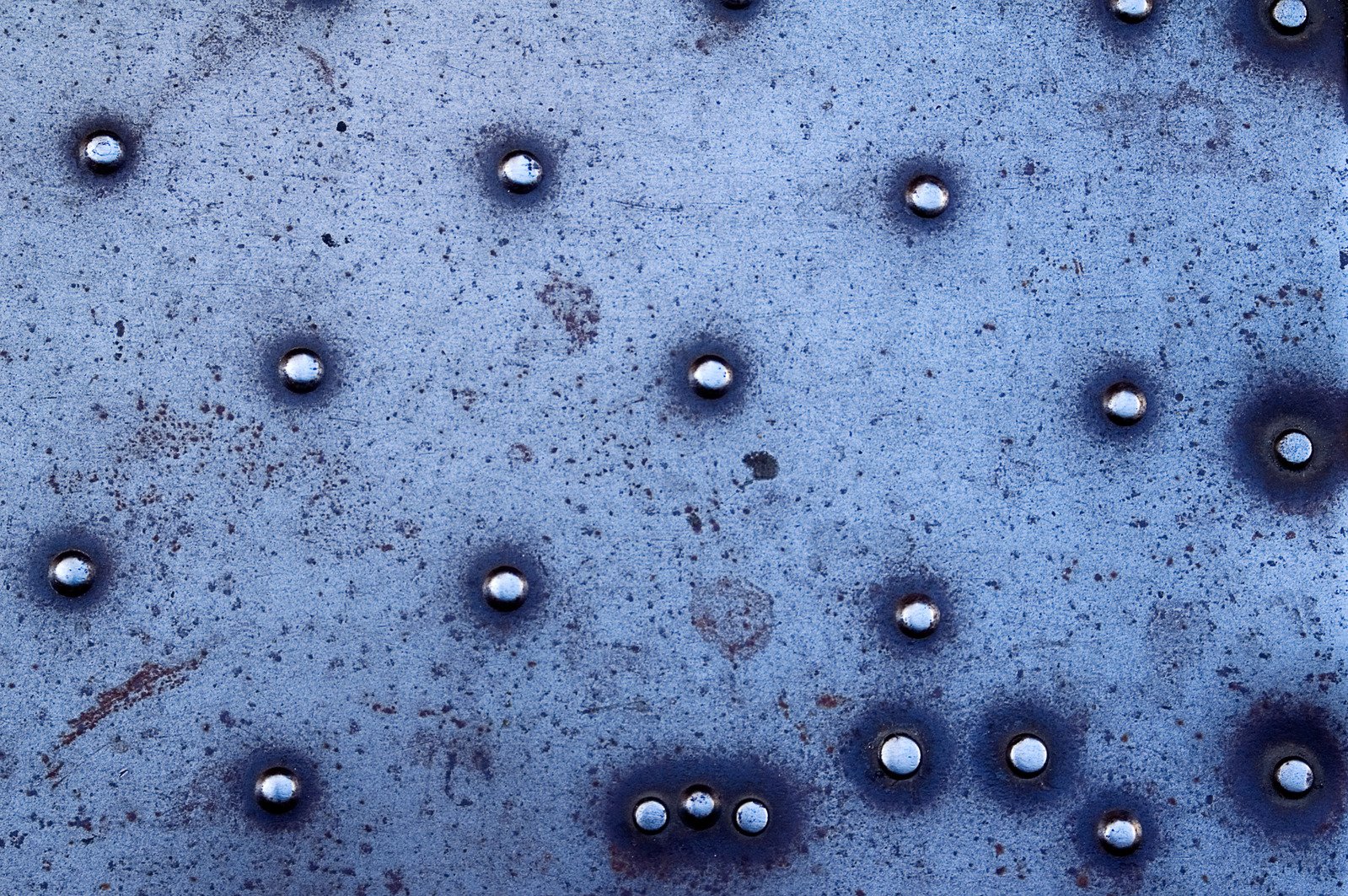 multiple metal balls and holes in an old surface