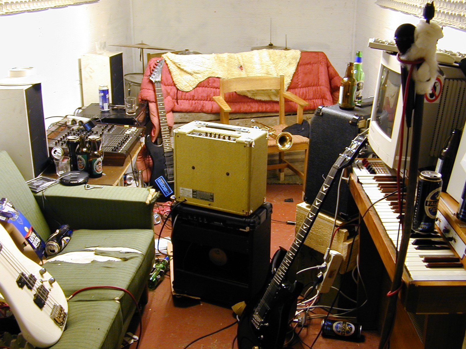the room is cluttered with guitars and musical equipment