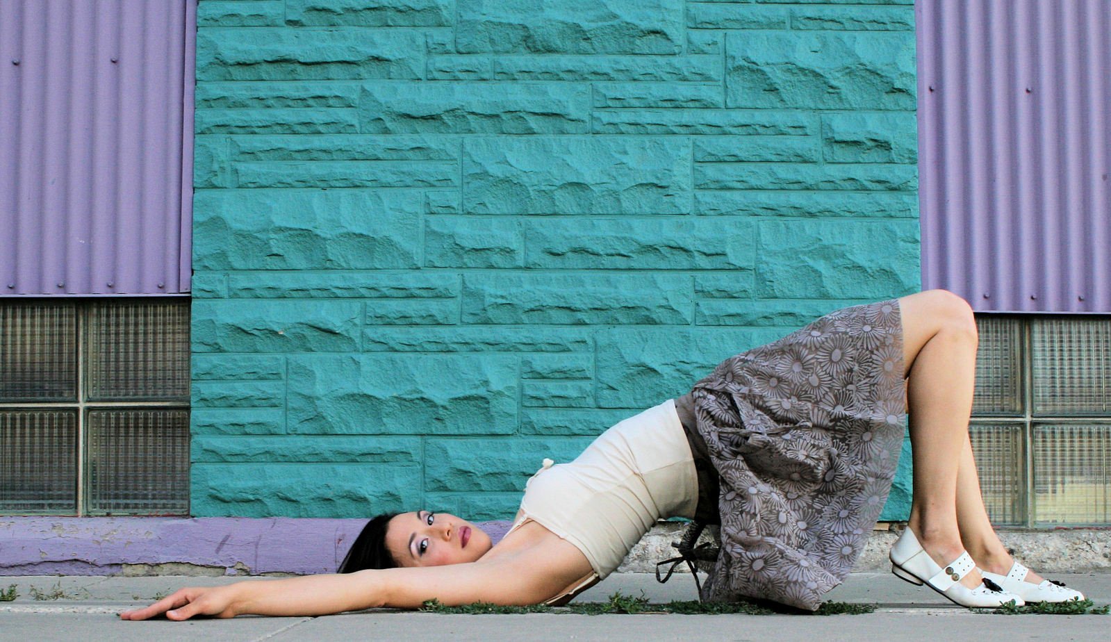 a woman laying on the ground next to a wall