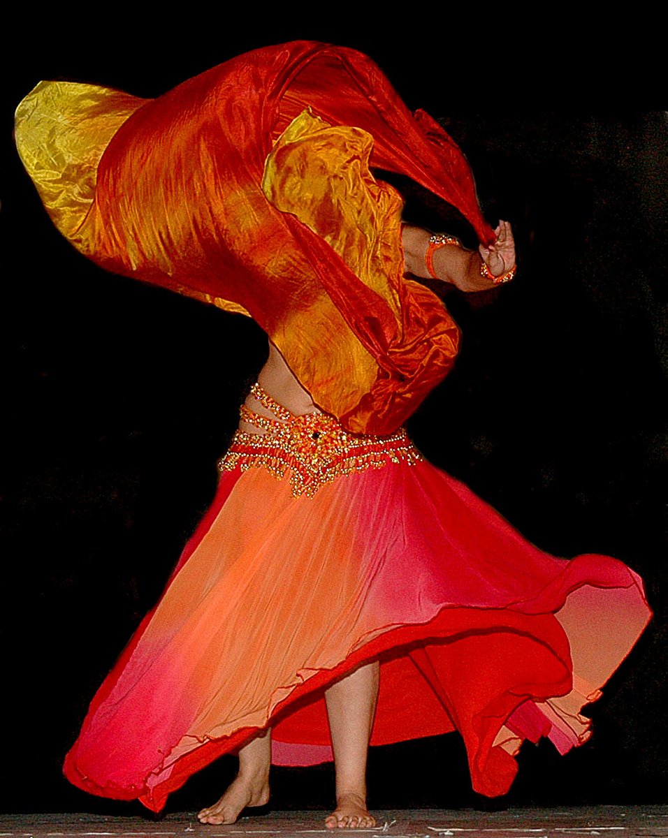 a woman dressed in yellow and red dancing
