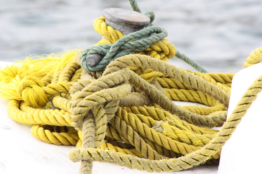 a bunch of yellow rope on top of a white boat