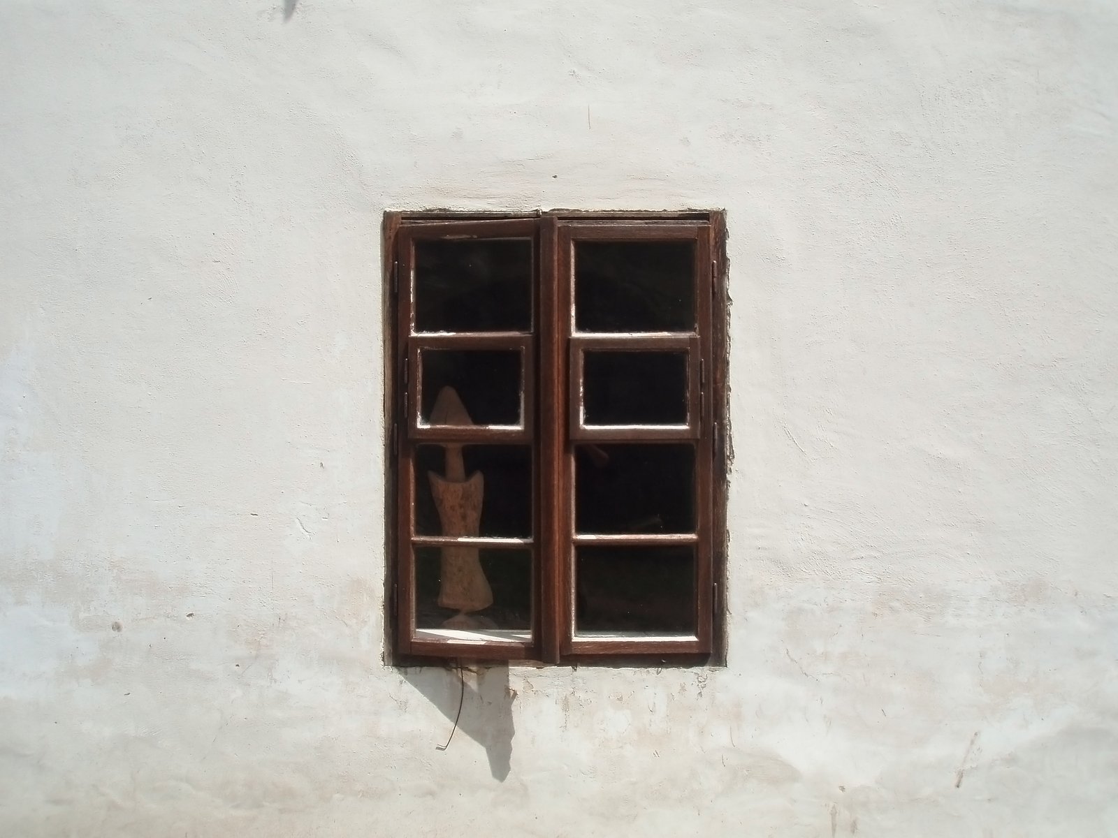 a stuffed animal in a room with three window panes