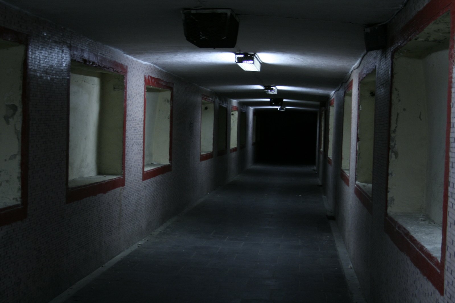 a very dark hallway with several windows and a red stripe around the edge