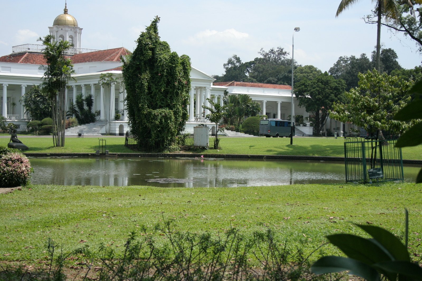 a house is near a pond in front of a white building