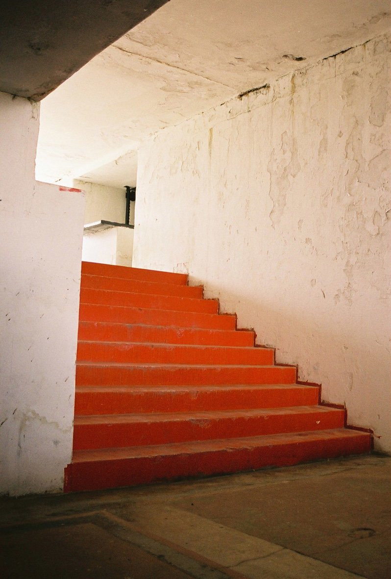 a set of red steps is shown in an empty building