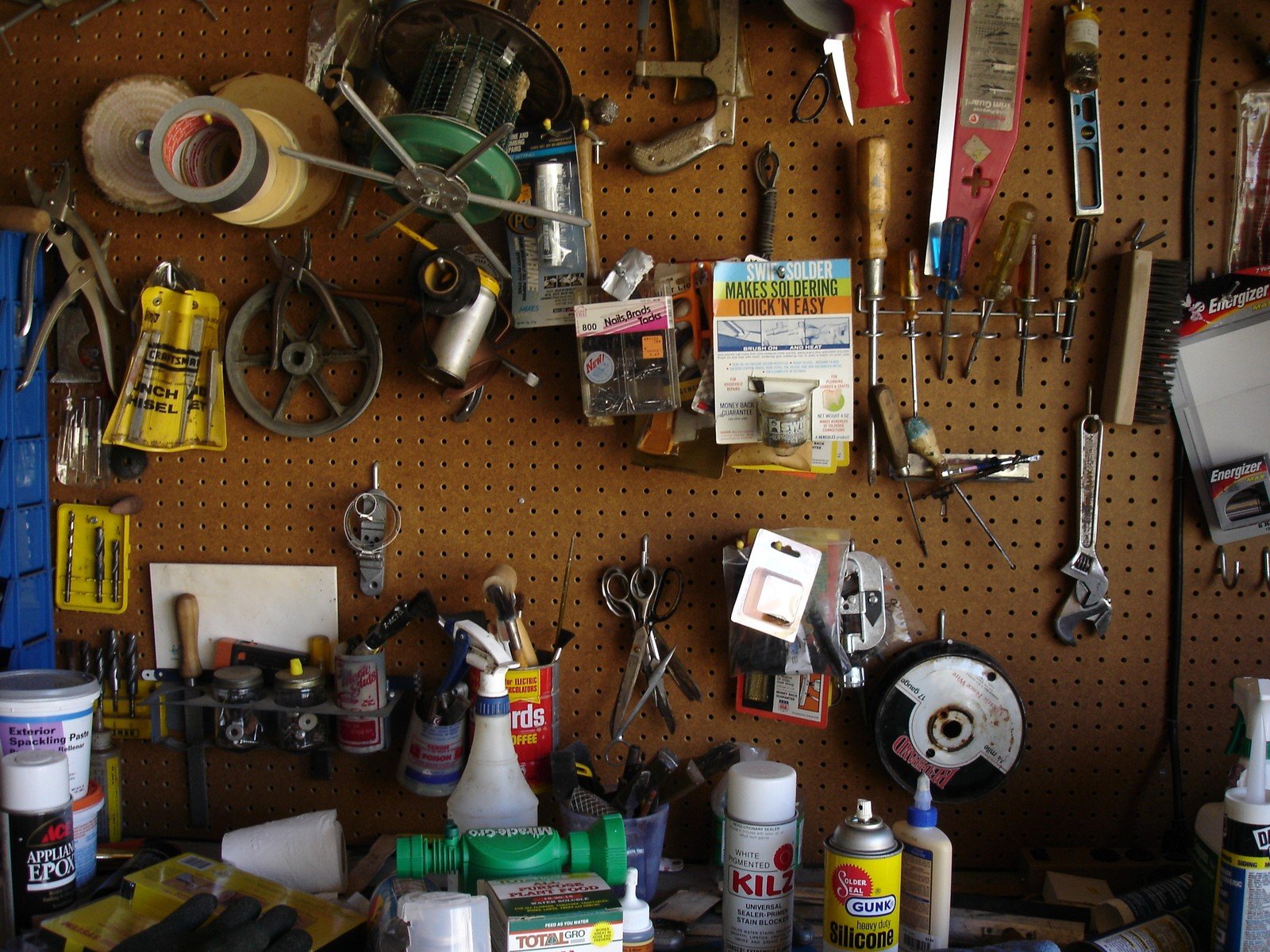 a pegboard with lots of tools hanging on it