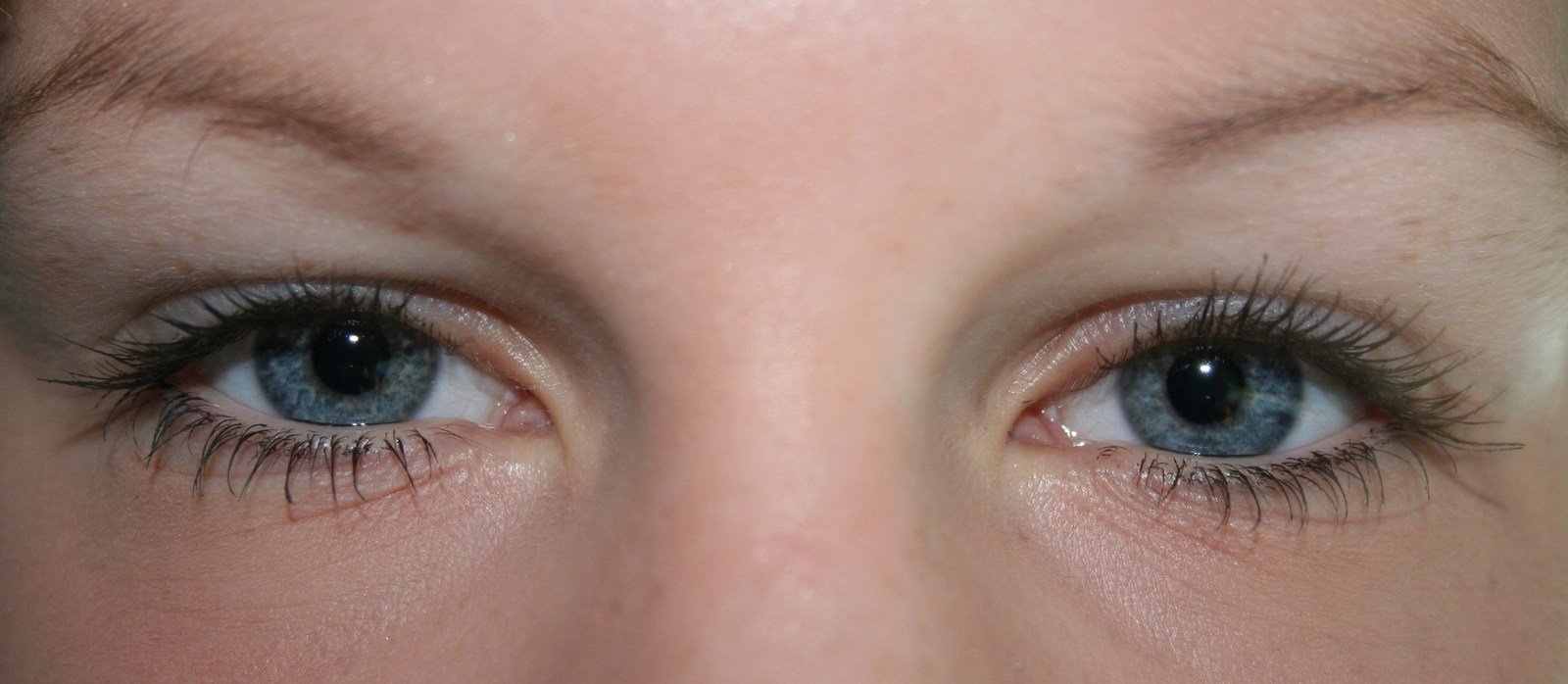 a woman with long, black lashes, brown eyes and blue eyes