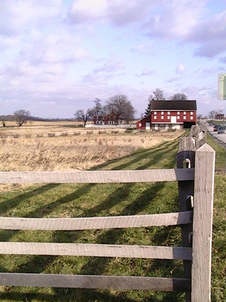 the long wooden fence is along the grassy path