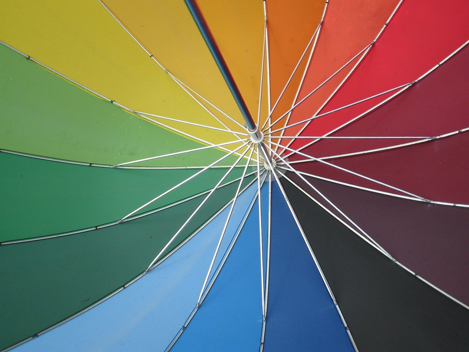 a rainbow colored umbrella close up with other colors