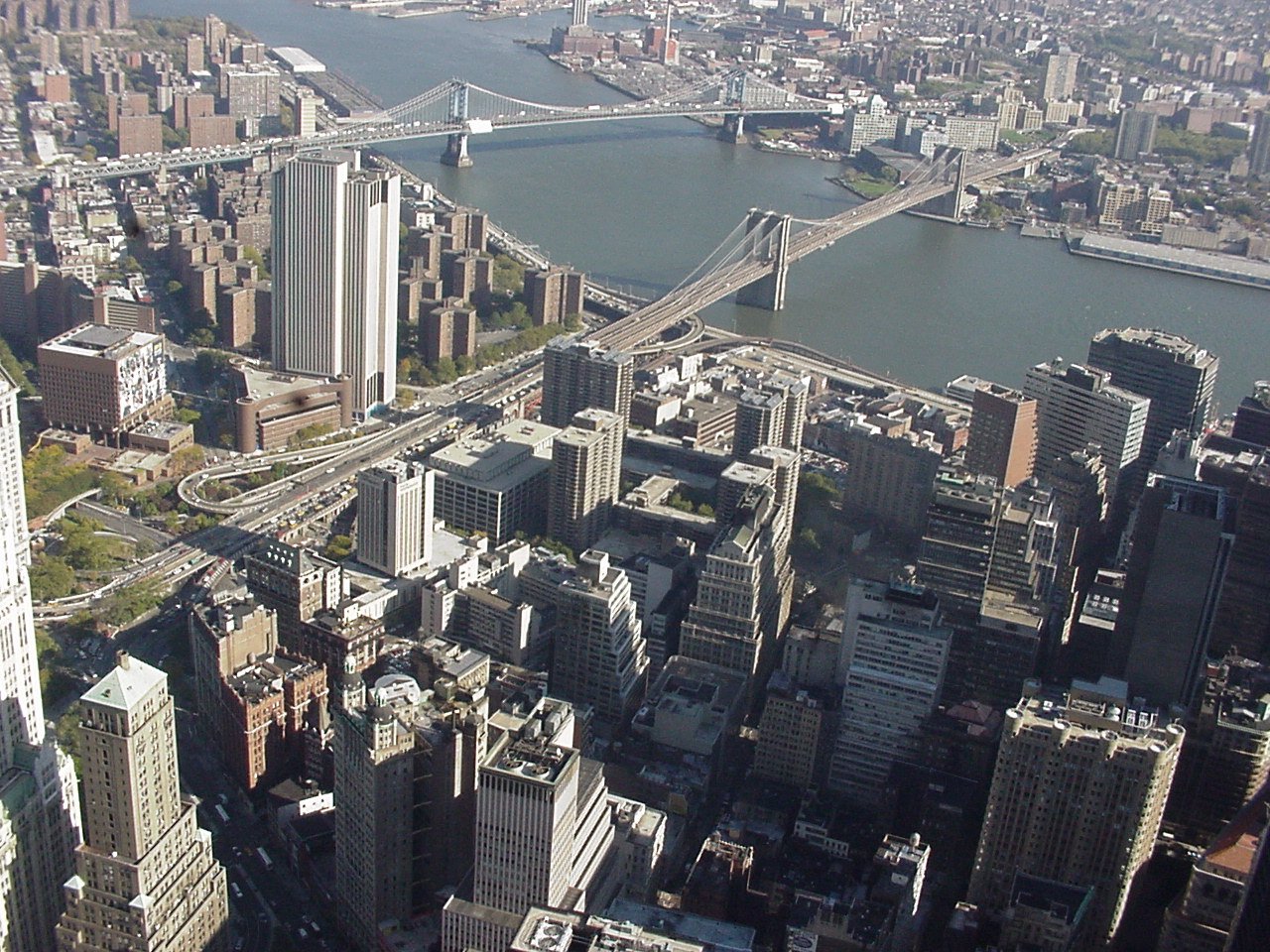 view of a city from the air, looking down at a bridge and water