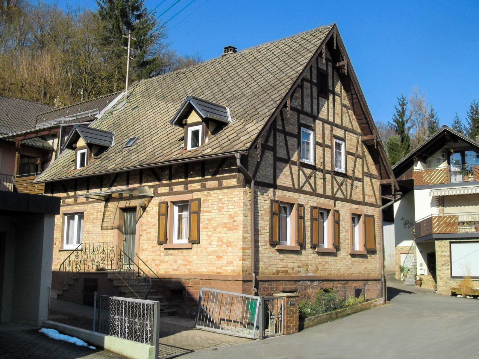 a large brown house with three dormers and lots of windows