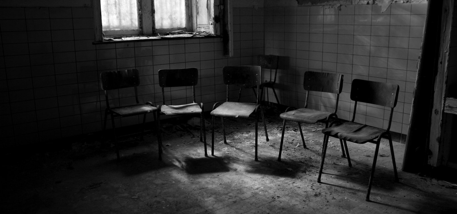 empty chairs in the middle of a room with tile walls