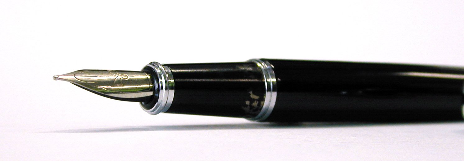a fountain pen lying on a white surface