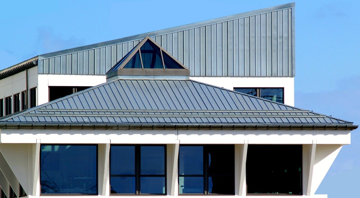 the roof of a white building has many windows