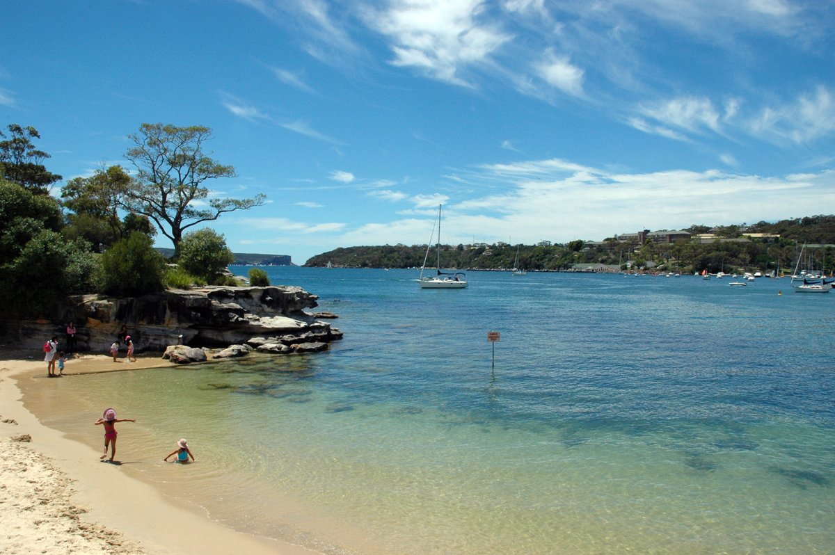 a beautiful beach with people swimming and walking around it