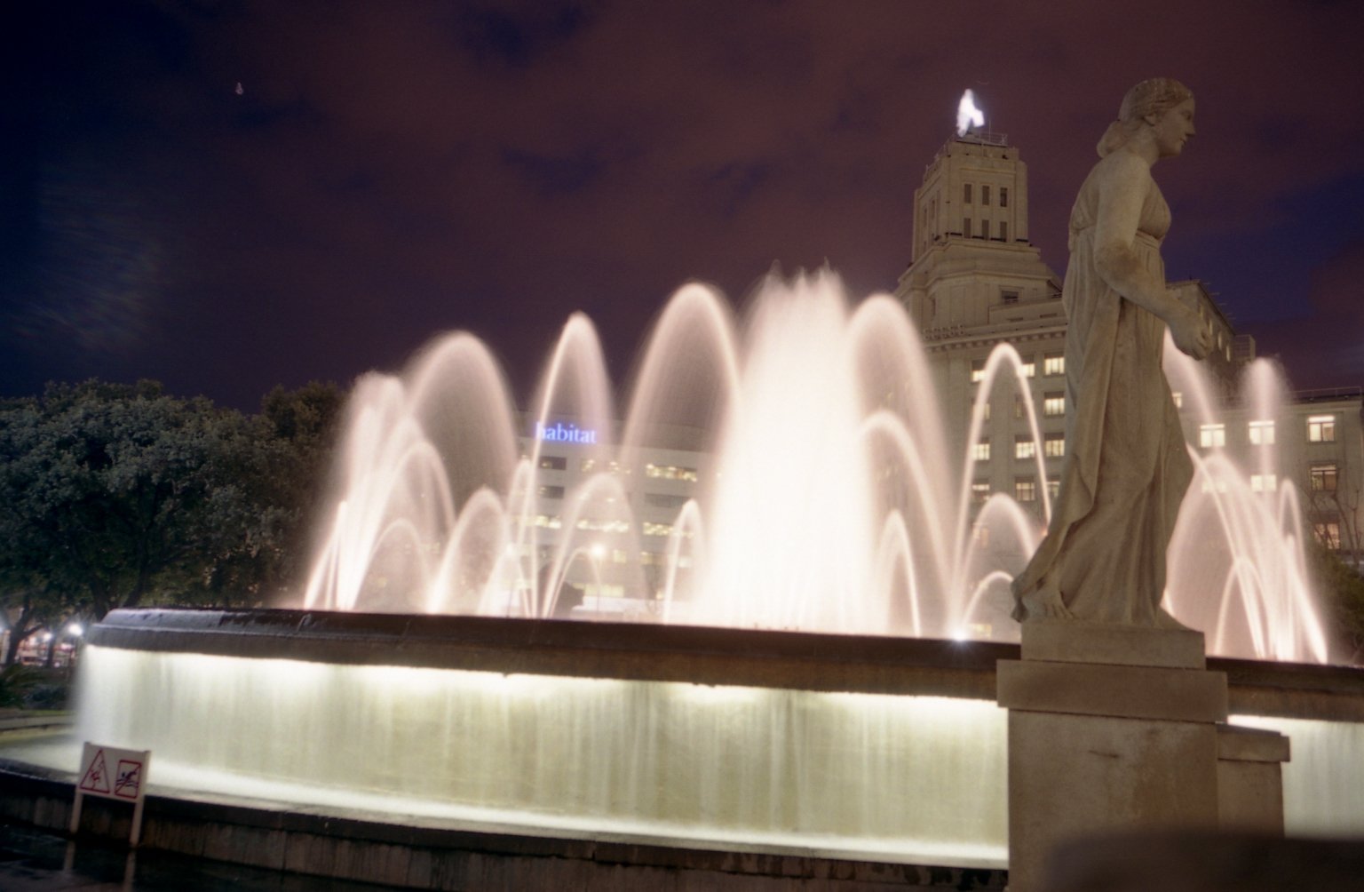 a large water fountain in front of a city building
