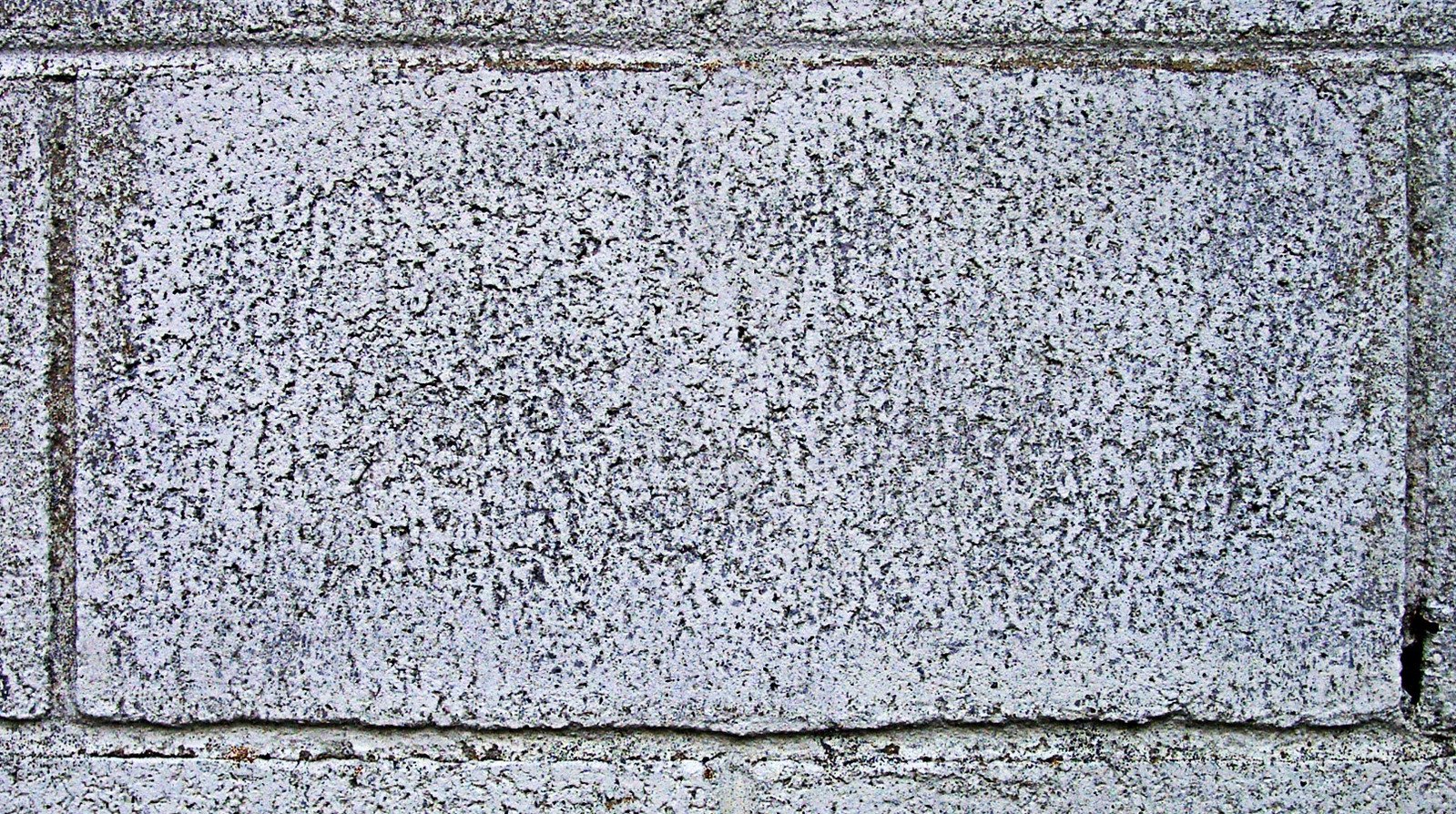 an old, gray cement wall is painted white