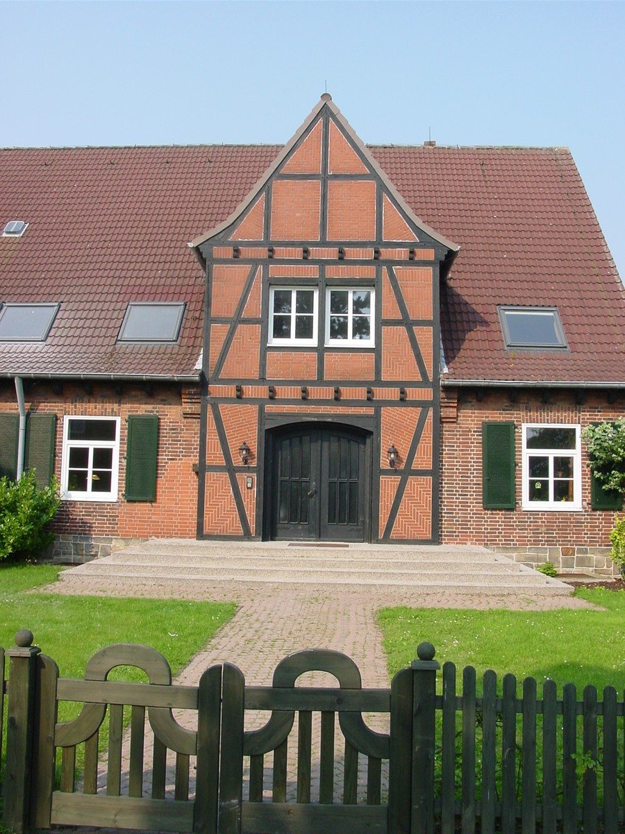 a large house with windows, shutters, and gate in front of it