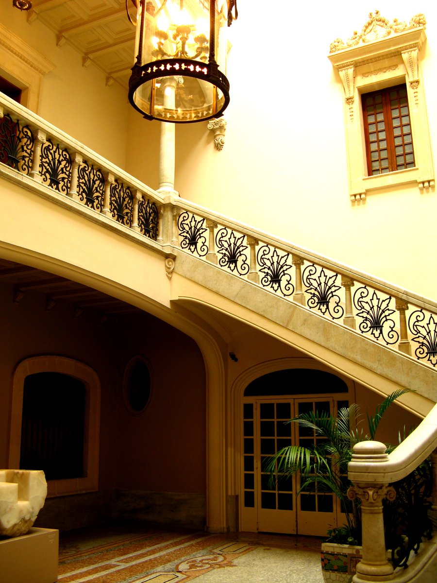 a fancy entryway with stairs, windows and wrought iron railing