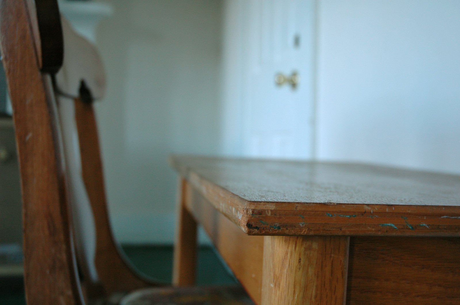 an old wooden table and two chairs in the room