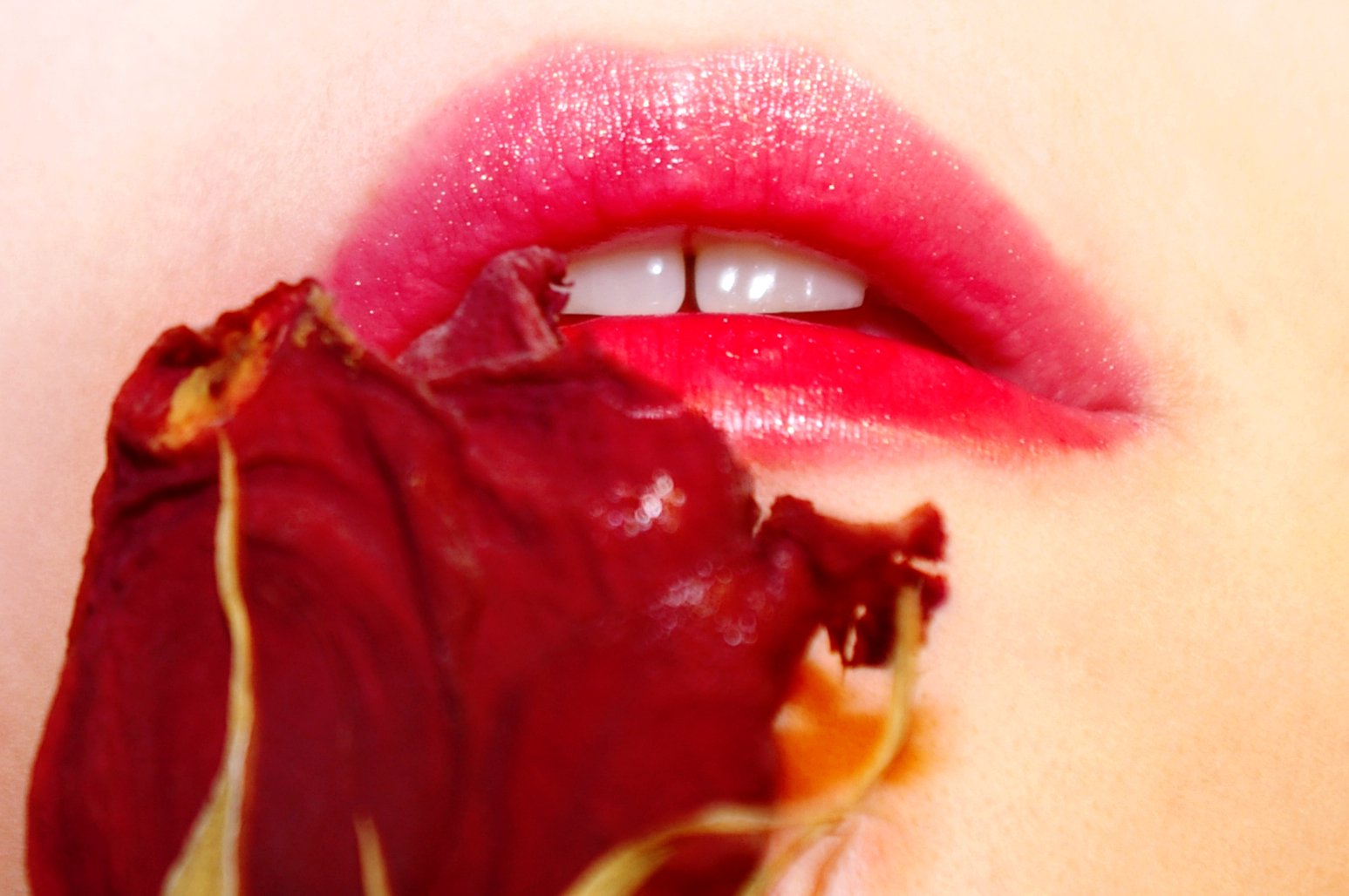 a close up view of a person's lips with rose petals