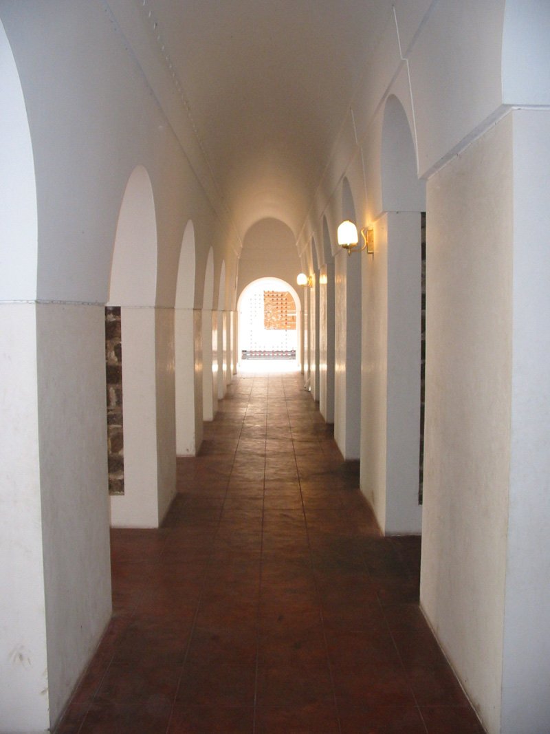 a line of white wall lined walkways leading to the entrance