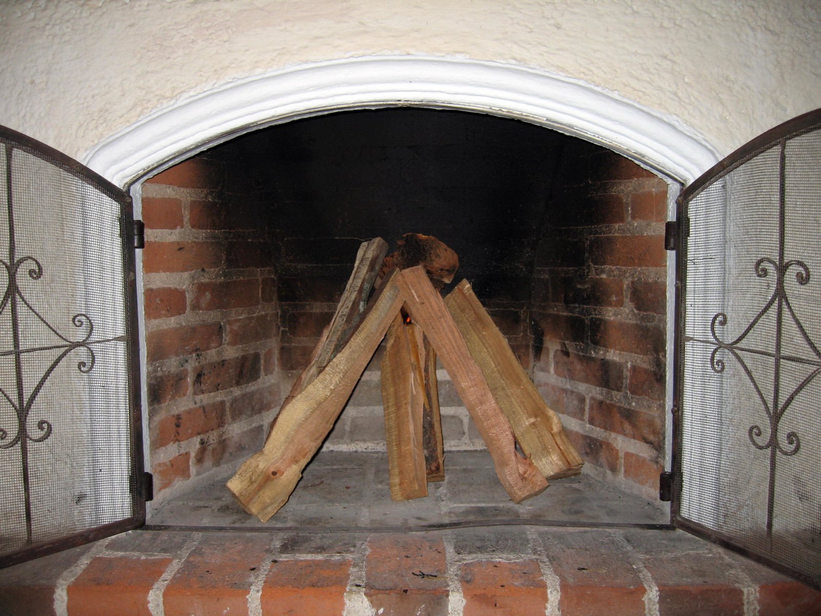 a close up of an open fireplace with fire logs