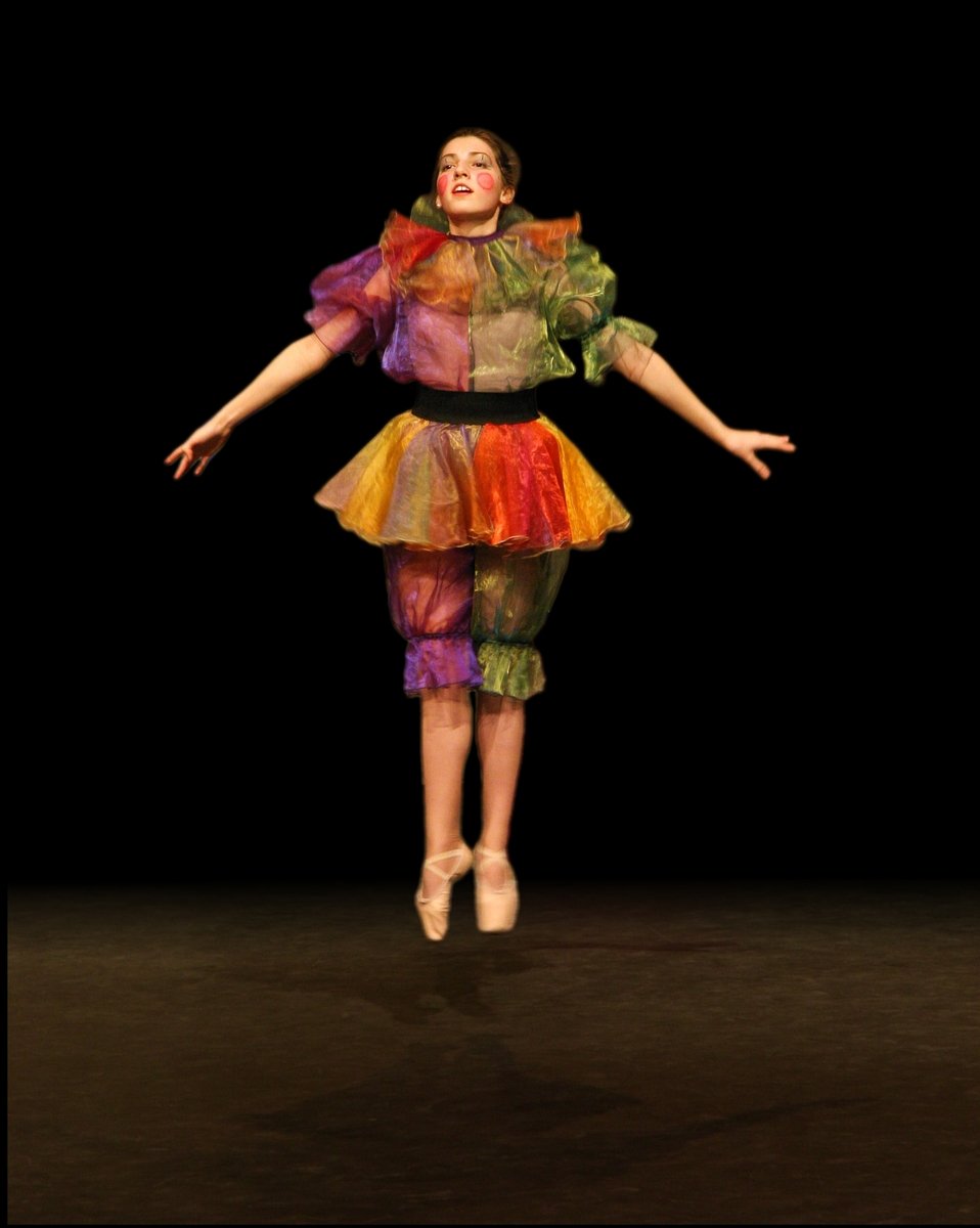 a woman is wearing a colorful outfit in a dance routine